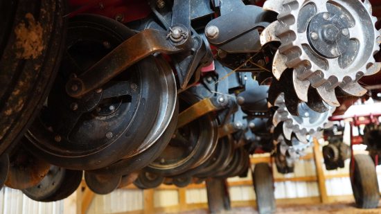 Detailed view of seed disc openers on a red planter during maintenance