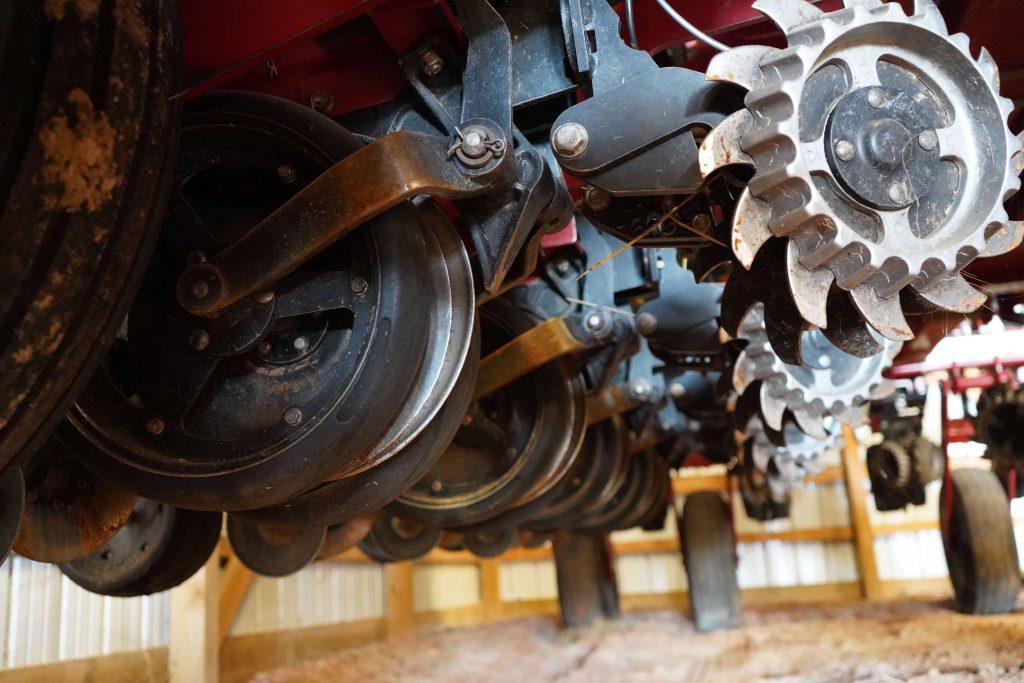 Close-up of row planter discs and gauge wheels in storage before spring planting.