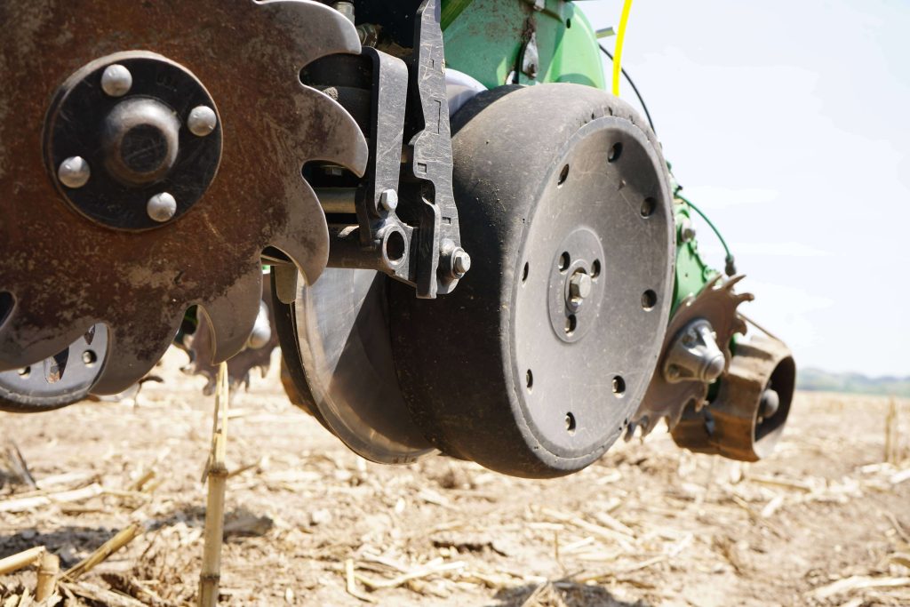 Close-up of agricultural tillage equipment showing disc openers and gauge wheels used in spring planting.